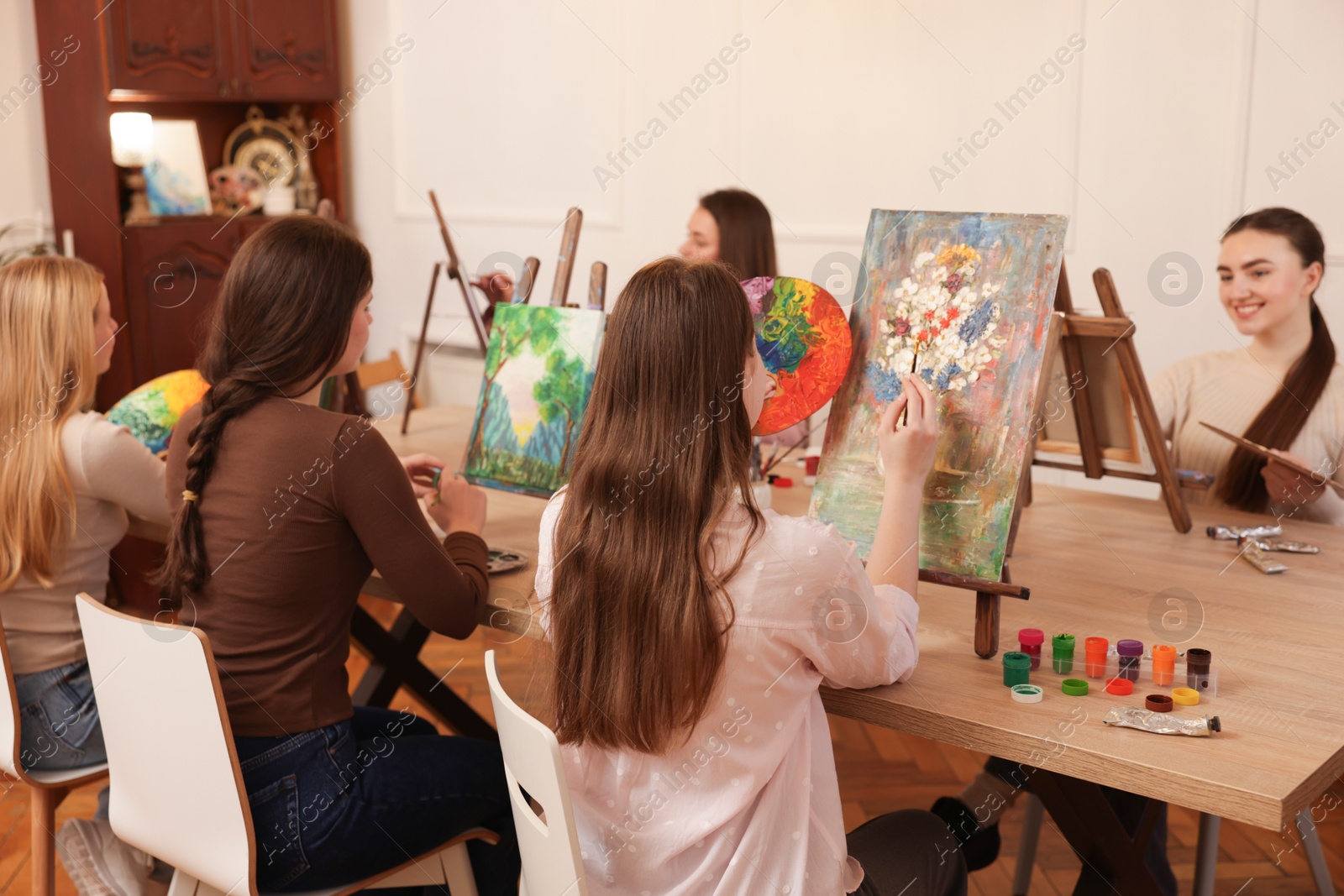 Photo of Group of women learning to draw at wooden table in class