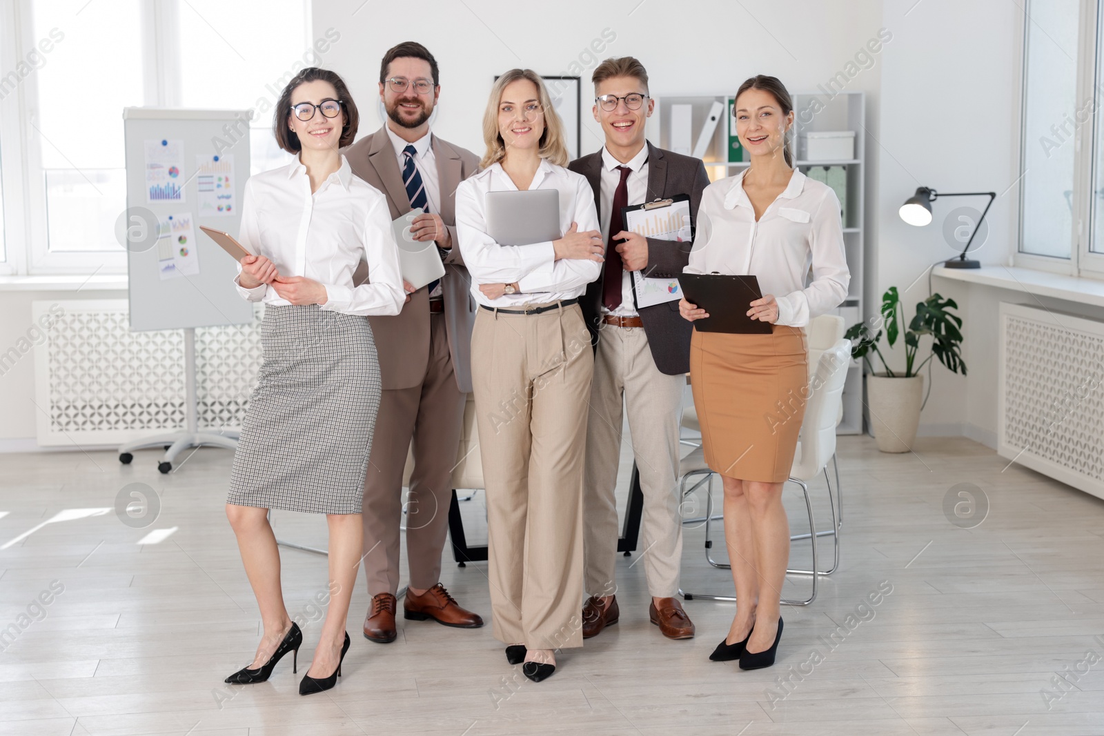 Photo of Portrait of happy coworkers in formal clothes indoors