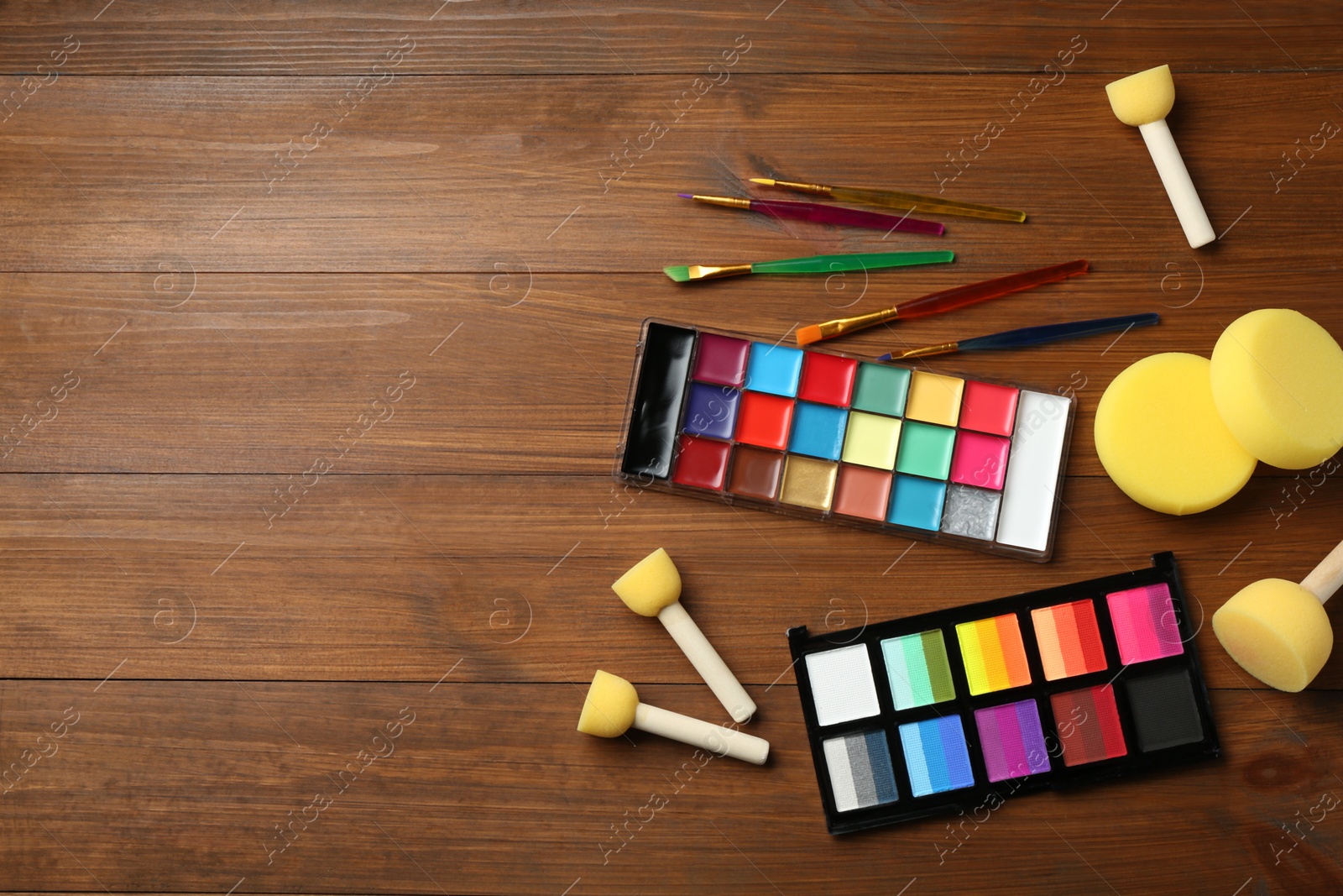Face paints and tools on wooden background, flat lay. Space for text Photo of Face paints and tools on wooden background, flat lay. Space for text