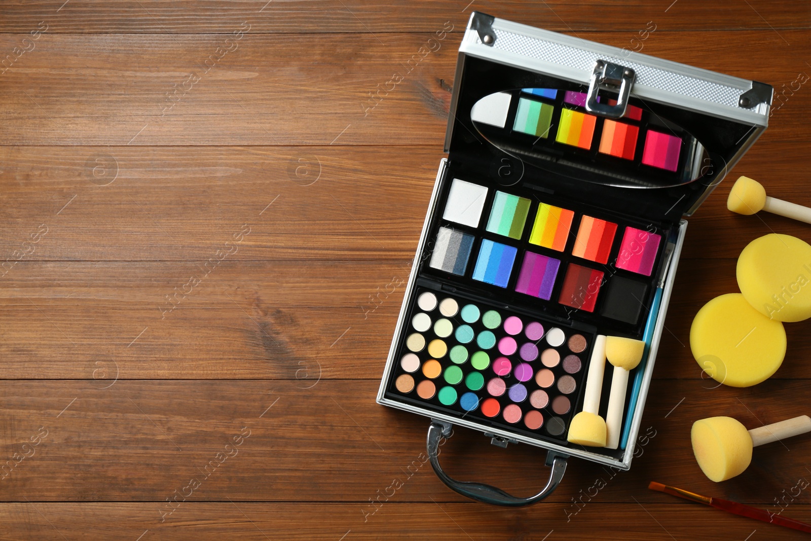 Face paints and tools on wooden background, top view. Space for text Photo of Face paints and tools on wooden background, top view. Space for text