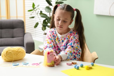 Photo of Little girl with handmade toy at home. Child creativity and craft