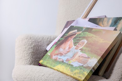 Photo of Canvas with different printed photos on armchair, closeup