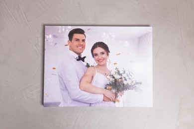 Photo of Canvas with printed photo of happy newlyweds on grey textured wall