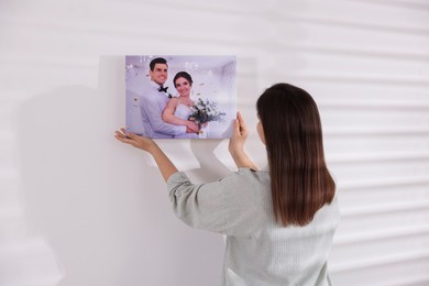 Photo of Canvas print. Woman hanging photo on wall at home