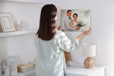 Photo of Canvas print. Woman hanging photo on wall at home