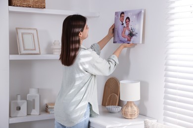 Photo of Canvas print. Woman hanging photo on wall at home