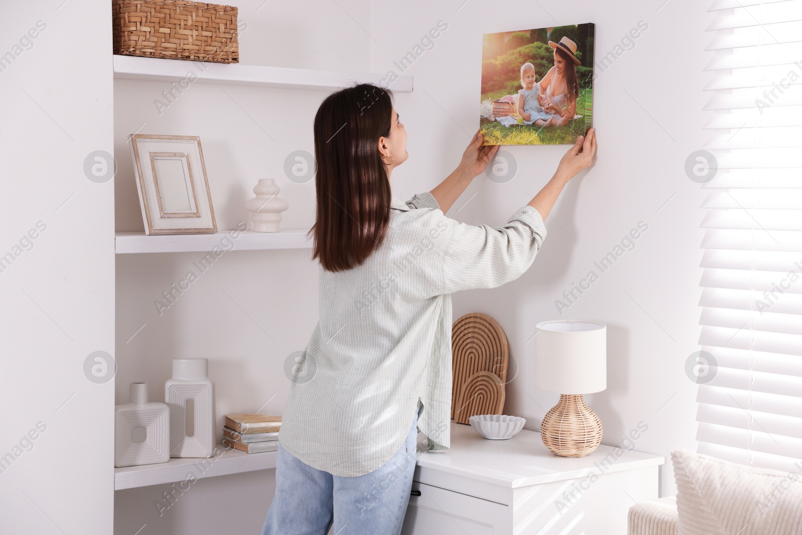 Photo of Canvas print. Woman hanging photo on wall at home