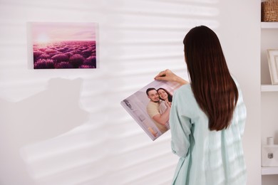 Photo of Canvas print. Woman hanging photo on wall at home