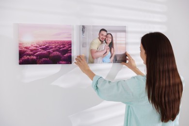 Photo of Canvas print. Woman hanging photo on wall at home