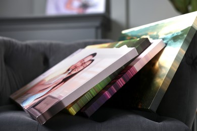 Photo of Canvas with different printed photos on armchair indoors, closeup