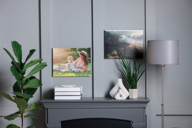 Photo of Canvas with printed photos on wall over decorative fireplace indoors