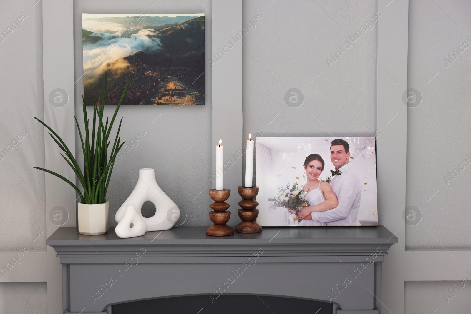 Photo of Canvas with printed photo and decor on fireplace indoors