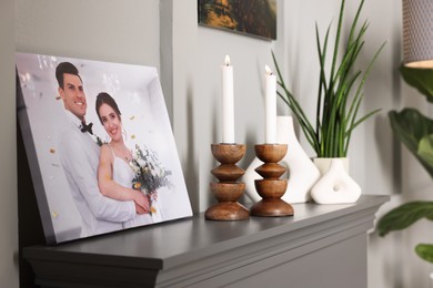 Photo of Canvas with printed photo and decor on table indoors