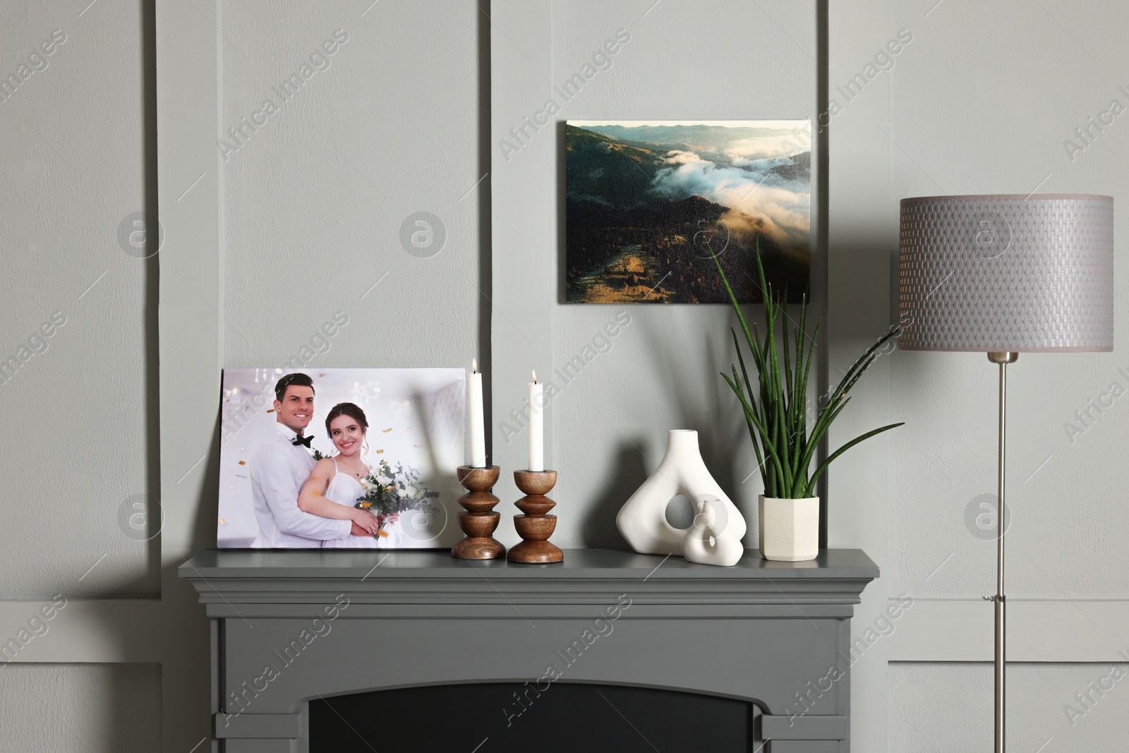 Photo of Canvas with printed photo and decor on fireplace indoors