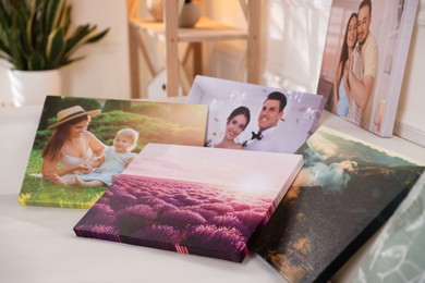 Photo of Canvas with different printed photos on table, closeup