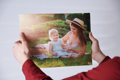 Photo of Canvas print. Woman with photo on light background, closeup