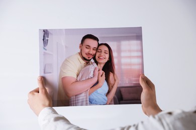 Photo of Canvas print. Woman with photo on light background, closeup