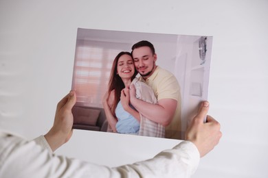 Photo of Canvas print. Woman with photo on light background, closeup