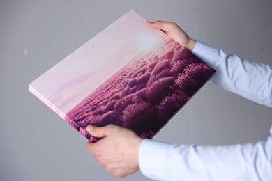 Photo of Canvas print. Woman with photo on light background, closeup