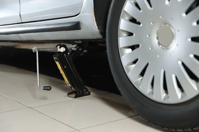 Photo of Car lifted by scissor jack at service station