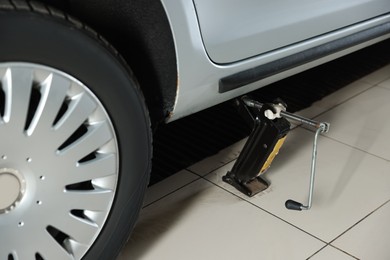 Photo of Car lifted by scissor jack at service station