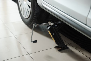 Photo of Car lifted by scissor jack at service station