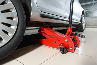 Photo of Car lifted by scissor jack at service station