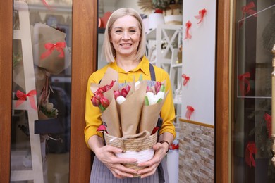 Photo of Business owner with beautiful tulips at door of her flower shop