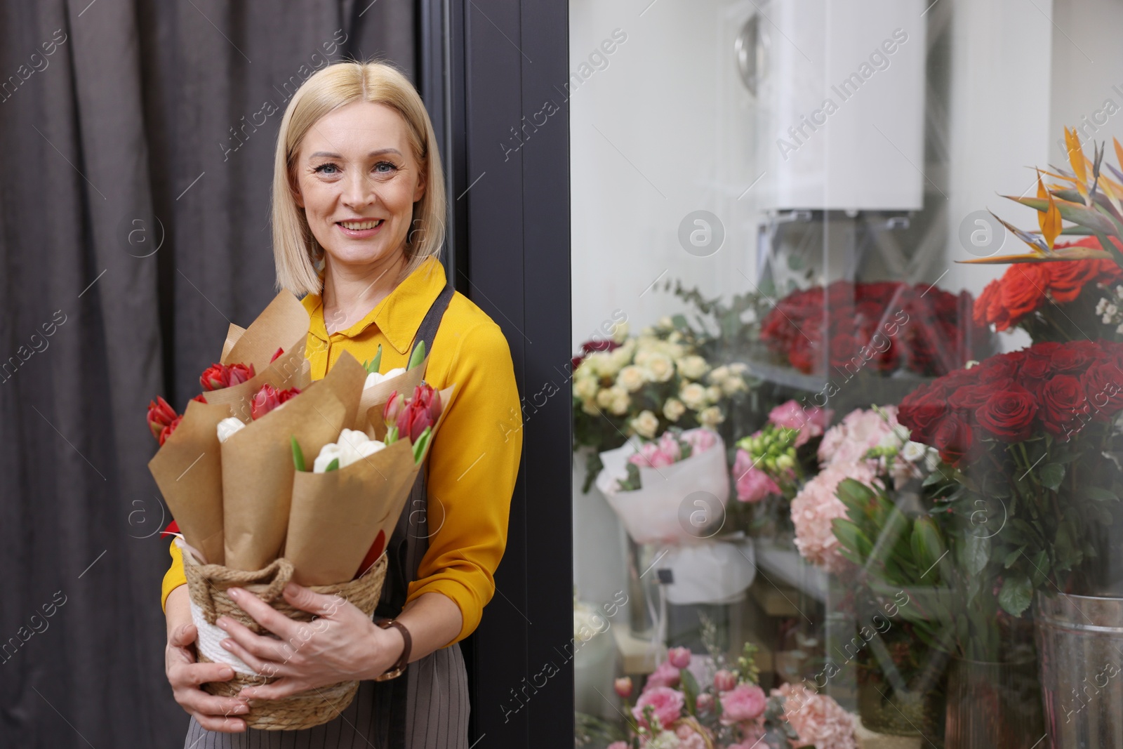 Photo of Business owner with beautiful tulips in her flower shop