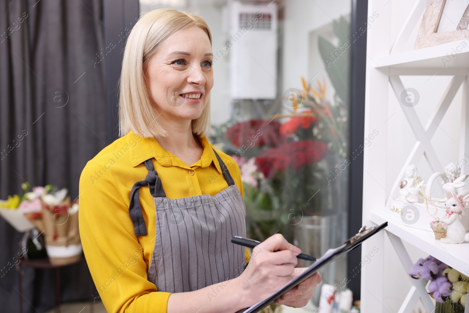 Photo of Business owner with clipboard taking notes in her flower shop