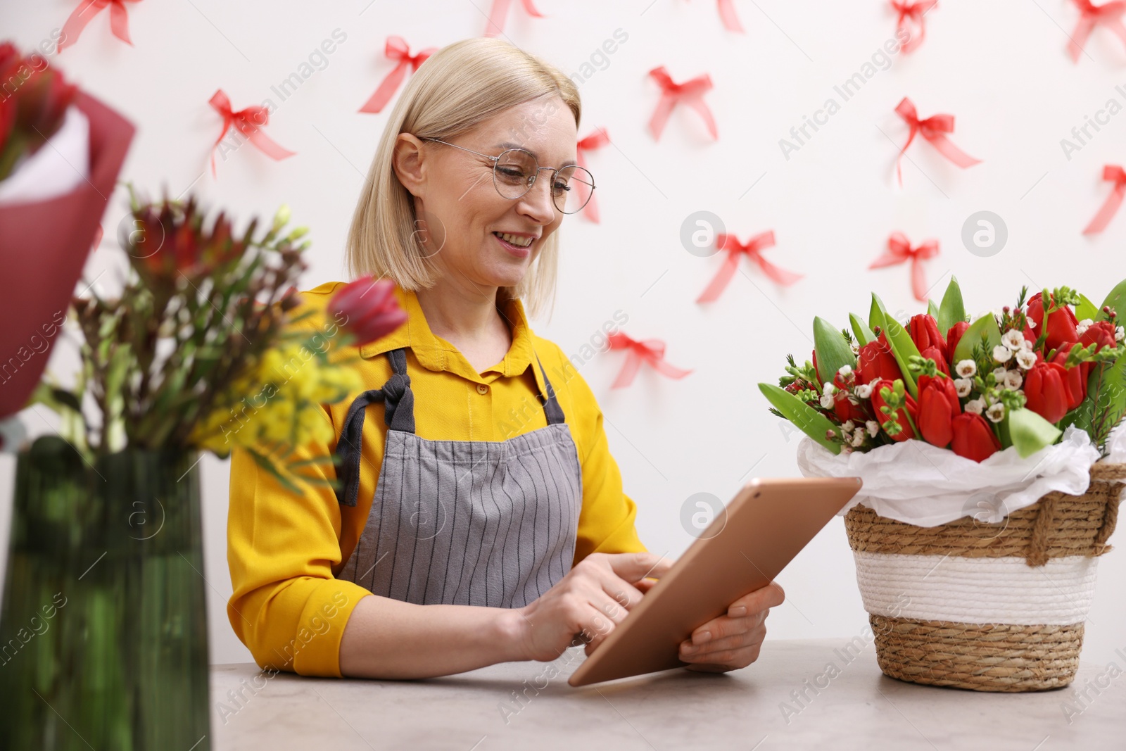 Photo of Business owner with tablet at table in her flower shop