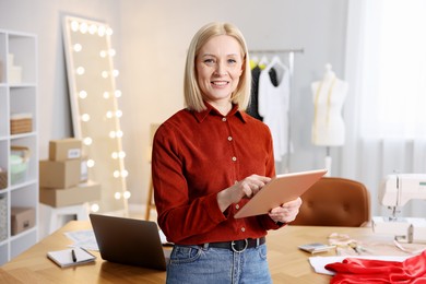 Photo of Business owner with tablet in her tailor shop