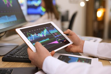 Photo of Stock exchange. Man working at desk in office, closeup