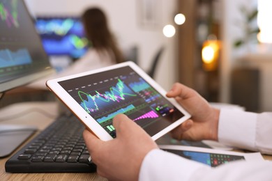 Photo of Stock exchange. Man working at desk in office, closeup