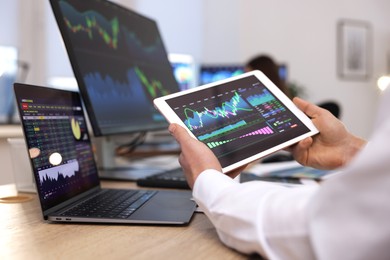 Photo of Stock exchange. Man working at desk in office, closeup