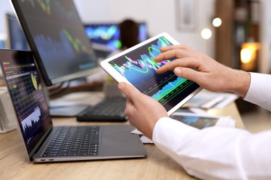 Photo of Stock exchange. Man working at desk in office, closeup