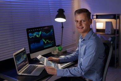 Photo of Stock exchange. Man working in office at night