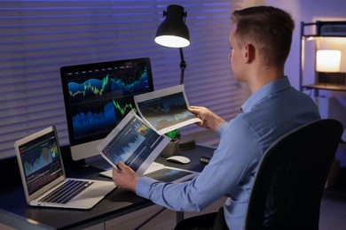 Photo of Stock exchange. Man working in office at night