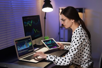 Photo of Stock exchange. Woman working in office at night