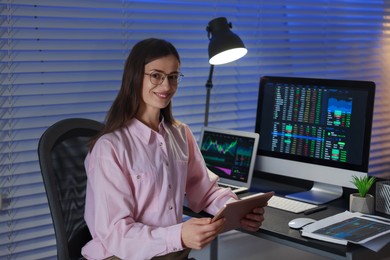 Photo of Stock exchange. Woman working in office at night