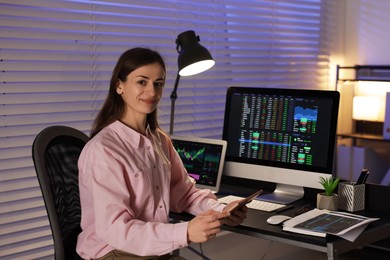 Photo of Stock exchange. Woman working in office at night