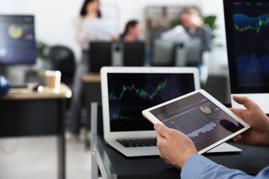 Photo of Stock exchange. Man working at desk in office, closeup