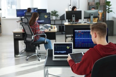 Photo of Stock exchange. Man working at desk in office