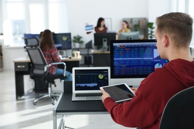 Photo of Stock exchange. Man working at desk in office