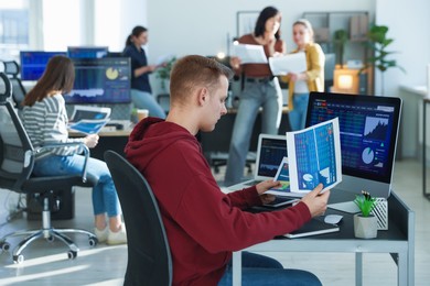 Photo of Stock exchange. Man working at desk in office