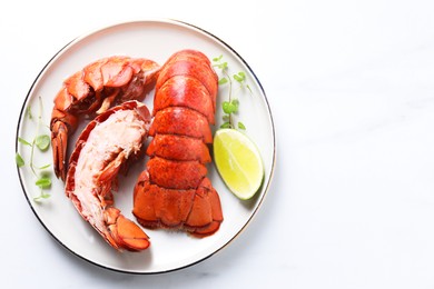 Photo of Delicious tails of boiled lobsters served on white table, top view. Space for text