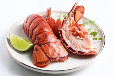 Photo of Delicious tails of boiled lobsters served on white table, closeup