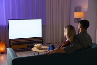 Photo of Lovely couple watching tv at home in evening