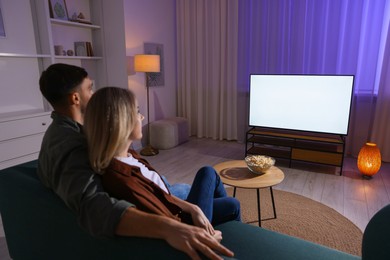 Photo of Lovely couple watching tv at home in evening