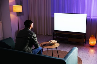 Photo of Man watching tv at home in evening